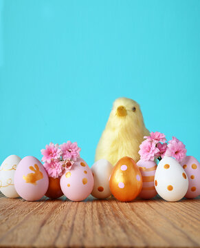 Easter Greeting Card with decorated eggs, flowers and cick on blue background
