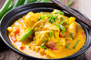 Traditional Thai fish curry with fish, vegetable and rice in spicy sauce served as close-up in...