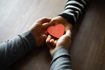 Hands of a woman holding and offering a heart shape. Love, health concept. Selective focus.Cinematic effect.