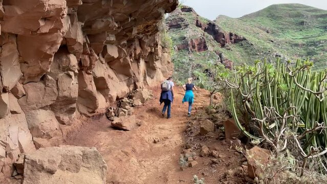 Hiking trail in Anaga mountains on Tenerife. Two young people making hiking tour from Punta del Hidalgo to Chinamada village.