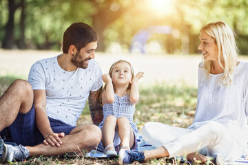 A happy family enjoying nature and having fun with their daughter