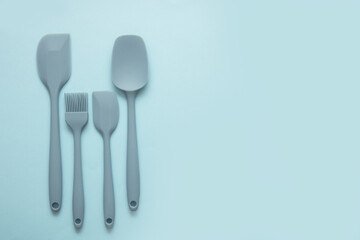 silicone blue cooking spatulas on a blue background with copy space