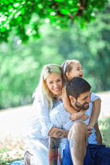 Fototapeta premium A happy family enjoying nature and having fun with their daughter