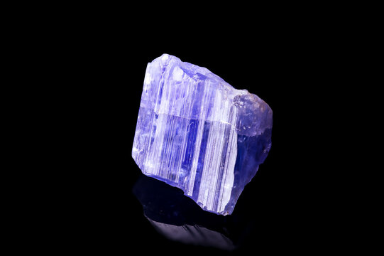 tanzanite (violet zoisite) crystal on black background. macro detail texture background. close-up raw rough unpolished semi-precious gemstone