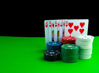 Royal flush cards and poker chips in stacks on the poker table.