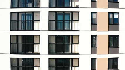 Fototapeta na wymiar Top view of windows and balconies of modern house. Stock footage. Beautiful exterior of residential building with modern windows. Modern residential building with new windows and stylish balconies