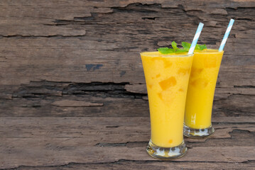 Mango juice fruit smoothies yogurt drink yellow healthy delicious taste in a glass slush for weight loss on wooden background.