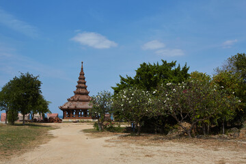 Naklejka premium A temple with a red roof and a blue sky in the background.