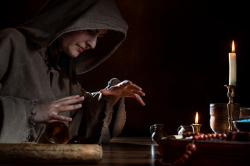 Medieval witch conjures with hands - product freedom