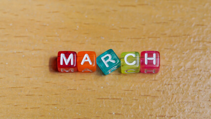 "march" word in colorful cubes. concept of months of the year, time. fun concept of time for kids