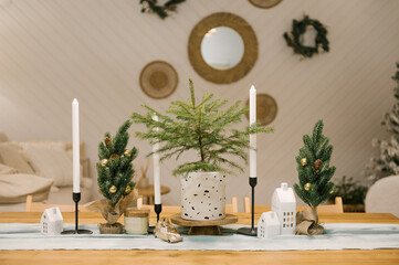 Interior of a beautiful light house decorated for New, white sofa, armchair and Christmas table