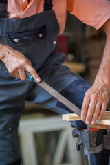 Carpenter using working tools while working on a wood in carpentry workshop