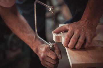 Carpenter using working tools while working on a wood in carpentry workshop