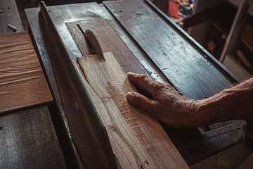 Carpenter using working tools while working on a wood in carpentry workshop