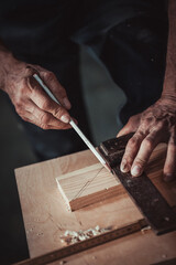 Carpenter using working tools while working on a wood in carpentry workshop