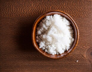 Fototapeta na wymiar sea salt in a wooden spoon on a brown background