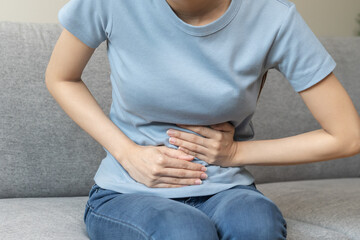 Flatulence asian young woman hand in stomach ache, suffer from food poisoning, abdominal pain and...