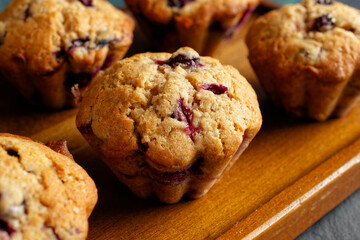Homemade blueberry muffins on a wooden serving tray. Close-up. 