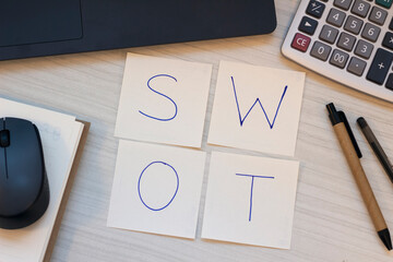 SWOT word written on papers on office desk.Business analysis concept.	