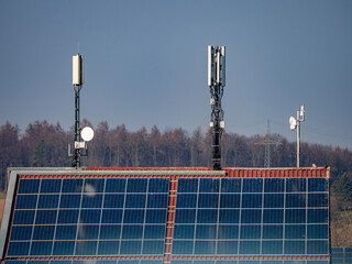 Funkmasten und Solar panels auf großem Dach