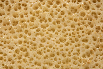 a close-up of a section of cheese with holes