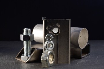 composition of nuts bolts and scraps of metal laid out on a dark background.