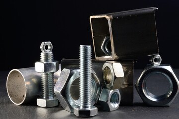 composition of nuts bolts and scraps of metal laid out on a dark background.