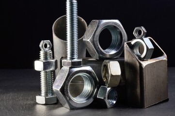 composition of nuts bolts and scraps of metal laid out on a dark background.