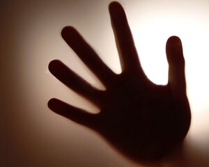 palm in the light of frosted glass in a dark room