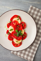Caprese salad, Italian traditional dish, tomatoes with mozzarella cheese, basil and spices, top view, no people,