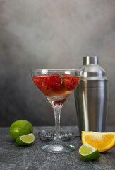 fresh cool strawberry cocktail with champagne with shaker on a gray background.