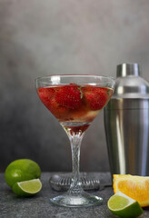 fresh cool strawberry cocktail with champagne with shaker on a gray background.