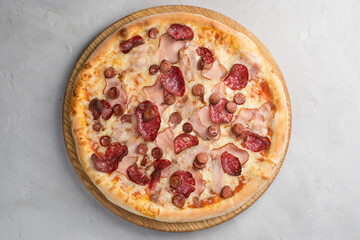 Pizza with vegetables, sausages and ham