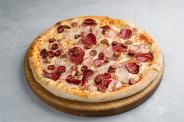 Pizza with vegetables, sausages and ham
