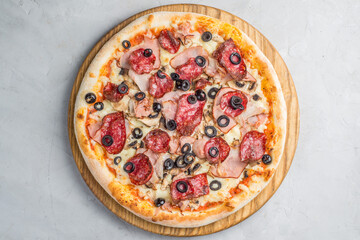 Pizza with vegetables, sausages and ham