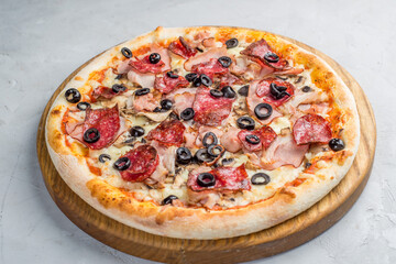 Pizza with vegetables, sausages and ham