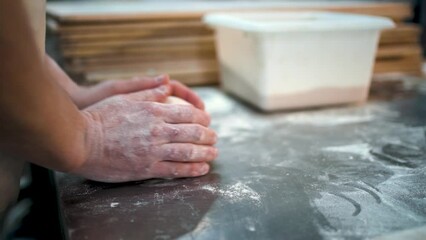 Professional baker preshaping bread dough during bread making proccess in bakery