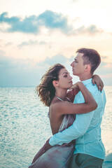 Young Couple Hugging On The Ocean Beach At Sunset In Maldives