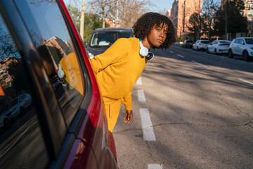 Obraz premium A girl runner trying to cross the road between cars.