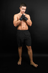 Fototapeta na wymiar Boxer prepared for a sparring. Photo of muscular man isolated on black background. Strength and motivation.
