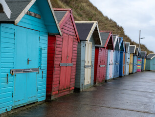 Fototapeta na wymiar Colourful beach huts along the promenade in the seaside town of Sheringham on the North Norfolk coast