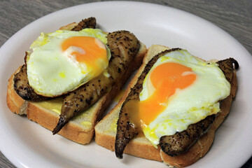 fried eggs on top of smoked mackerel fillets served on toast.