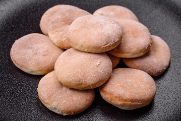 Fototapeta na wymiar Delicious fresh baked cornmeal shortcakes or cookies on a black plate