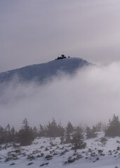 Foggy morning under Sniezka mountain in Karkonosze during winter in Poland