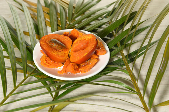 Chontaduro (Bactris gasipaes)Slices of the exotic tropical fruit of the palm tree Bactris gasipaes.Chontaduro with salt on a white plate on some palms