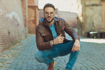 casual man posing with style in a squatted position