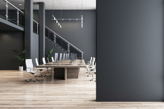 Blank black partition with place for advertising poster or logo in modern interior design spacious office hall with conference table, wooden floor and dark wall background. 3D rendering, mock up