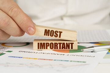 On the table are business charts and diagrams in the hands of a wooden block with the inscription -...