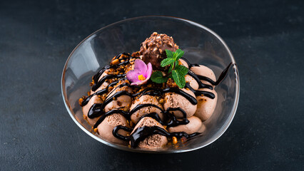 Tiramisu cake dessert with chocolate candy, nuts, mint and sweet sauce.