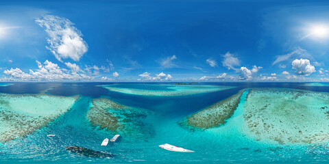 Fototapeta na wymiar Panoramic view of Vaavu Atoll, near Keyodhoo, Maldives, where a shipwreck sticks out of the water. A place for tourists engaged in diving and snorkeling. Aerial seamless 360 degree spherical panorama